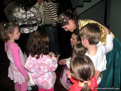 Senhorita Festiqueijo e Dama de Companhia abraçadas pelas crianças (Foto: romildo)