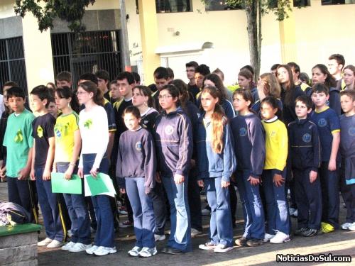 Aunos perfilados na execução do Hino Nacional juntamente com seus professores e autoridades (Foto: Romildo)